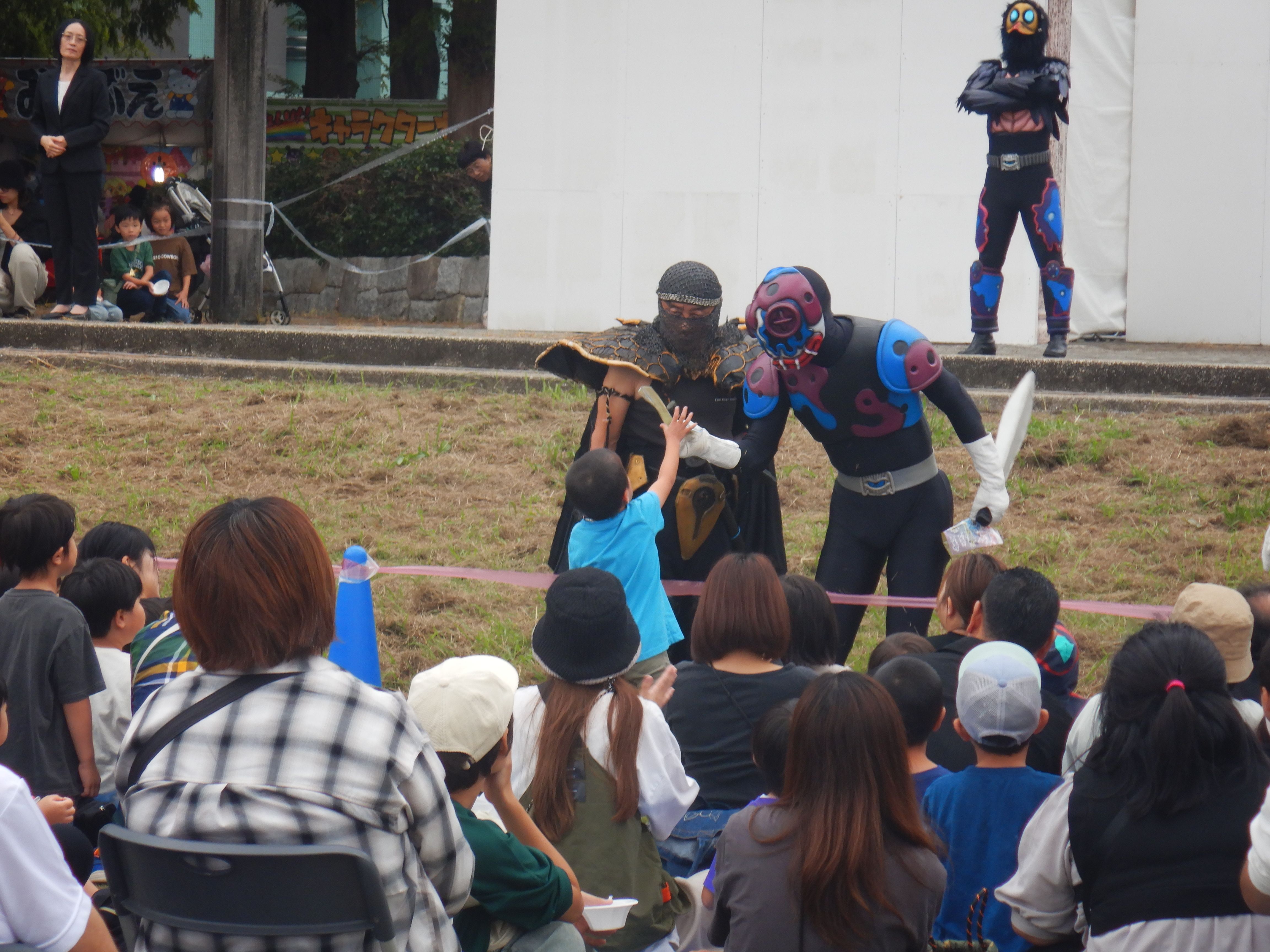 こどもがヒーローに触れ合っているイベントの様子