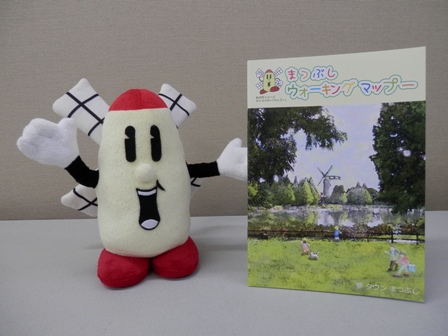 マップーのぬいぐるみと「まつぶしウォーキングマップー」の写真
