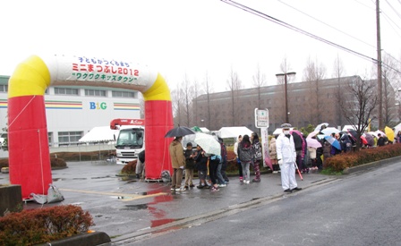 雨の中、開場を待つ人たちの写真
