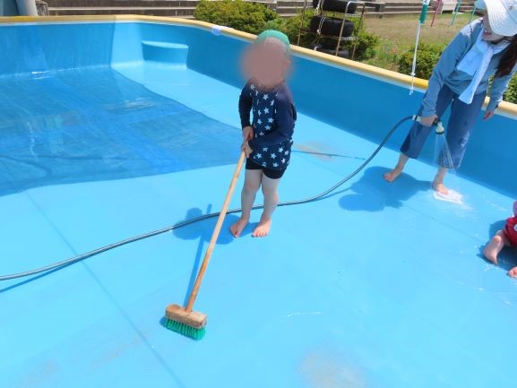 プール掃除をする園児の写真