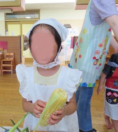 トウモロコシの皮をむく園児の写真その2