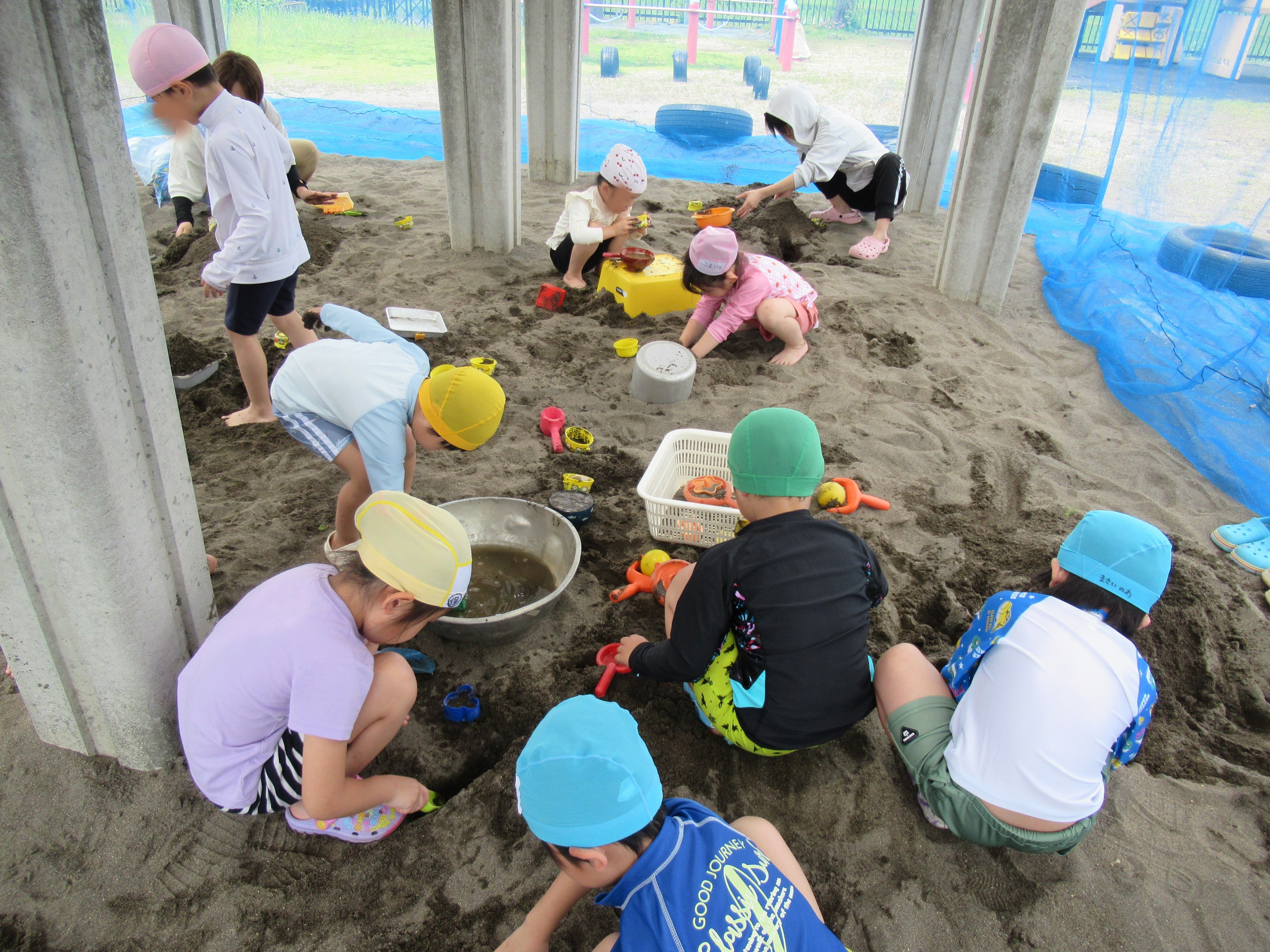 こどもたちが砂場で遊んでいる様子を捉えた画像