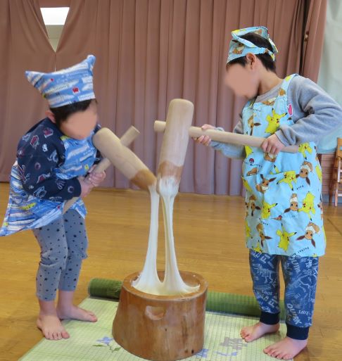 こどもたちが木の彫刻を見ながら話し合っている様子。