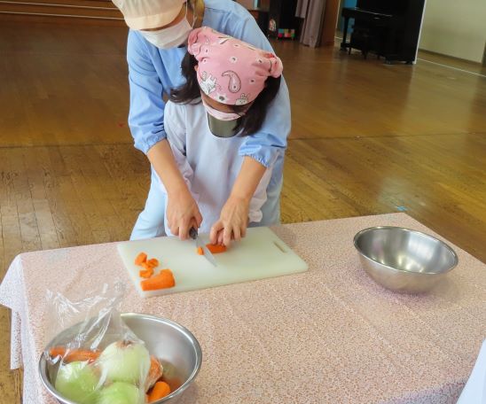 こどもたちがテーブルで料理をしている様子
