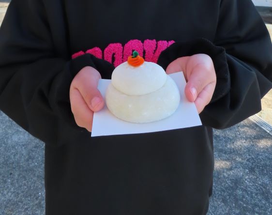 人物が手に雪だるまを持っている様子。