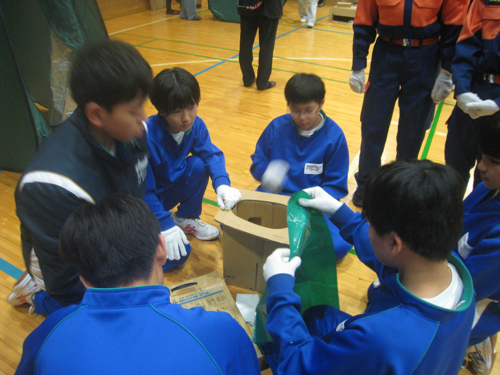 こどもたちが緑色の布を使って何かを取り組んでいる様子が写っている画像。