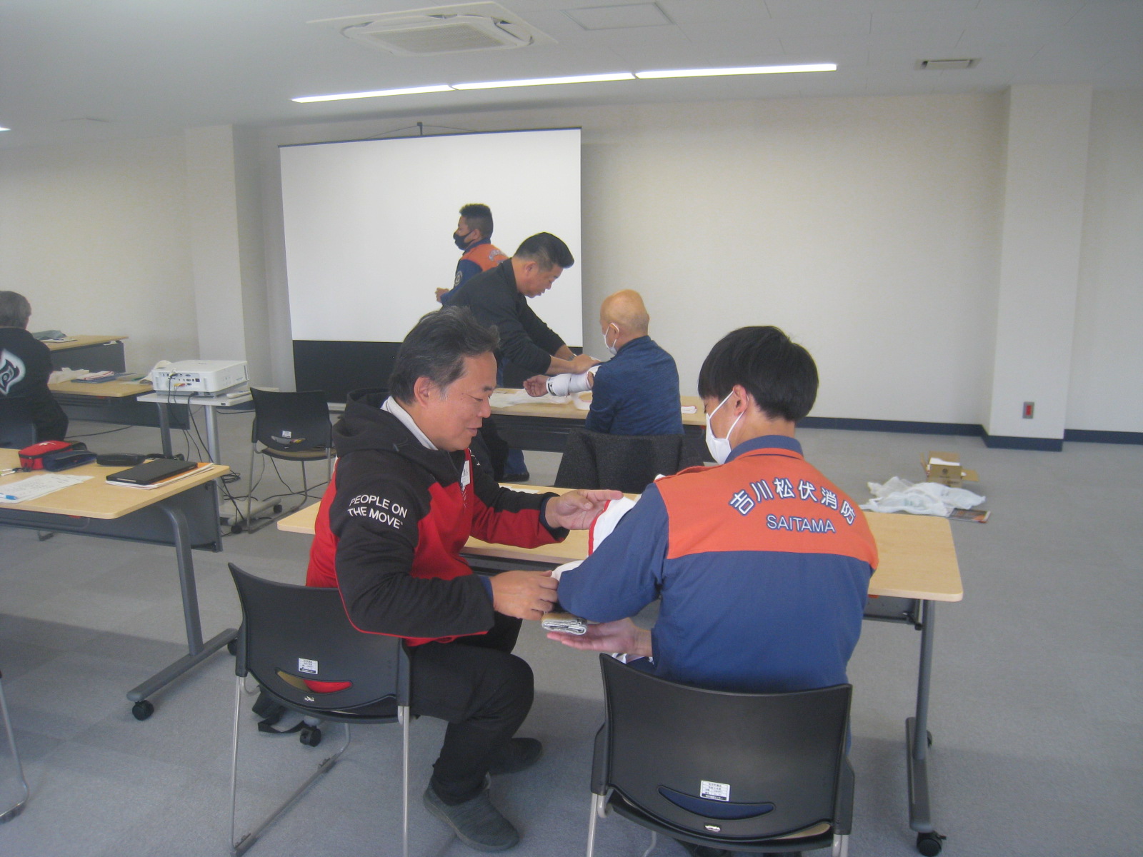 会議室で作業をしている数人の人々が見える。