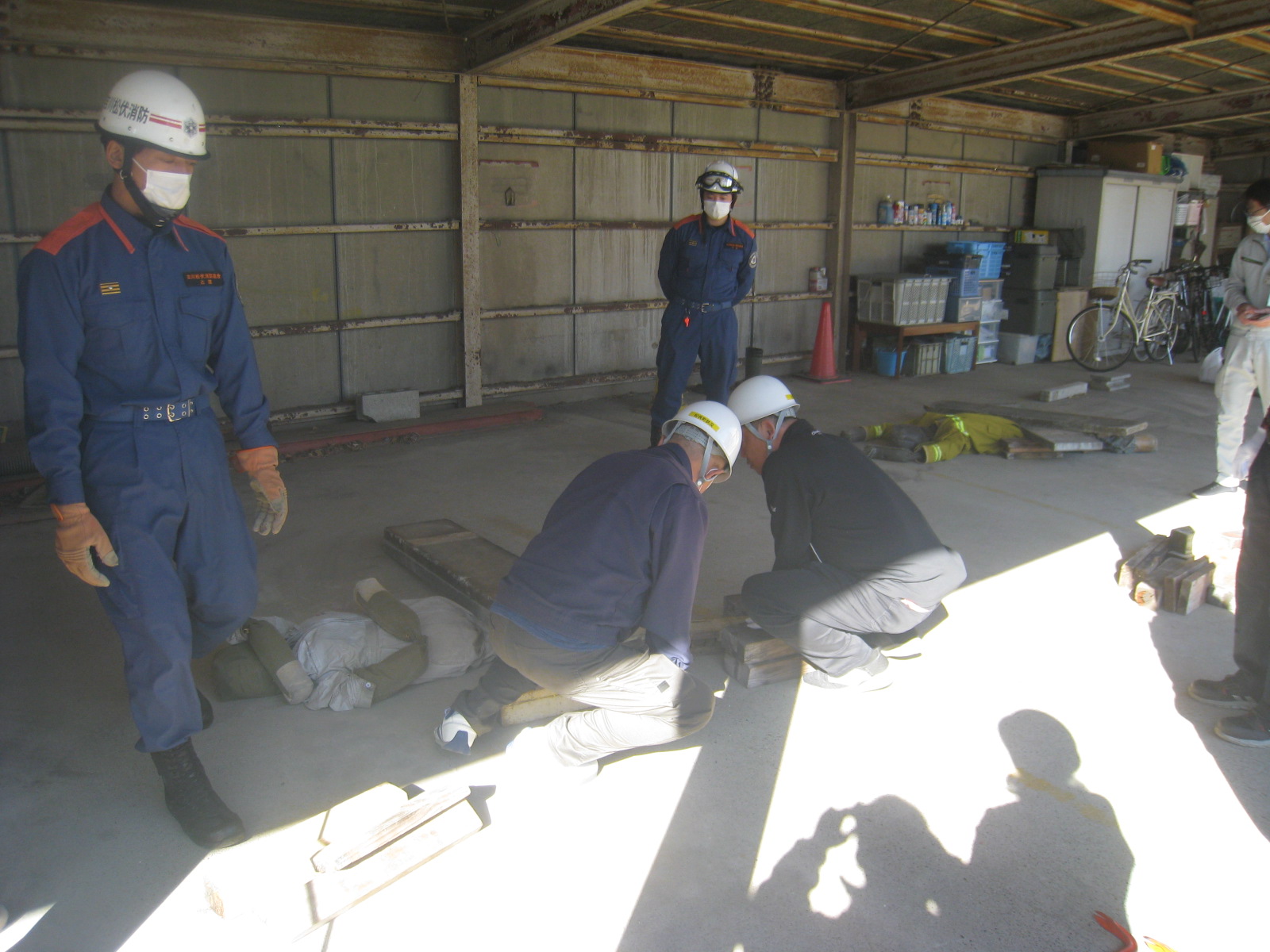 作業服を着た数人の人々が屋内で作業をしている様子が映っている画像。