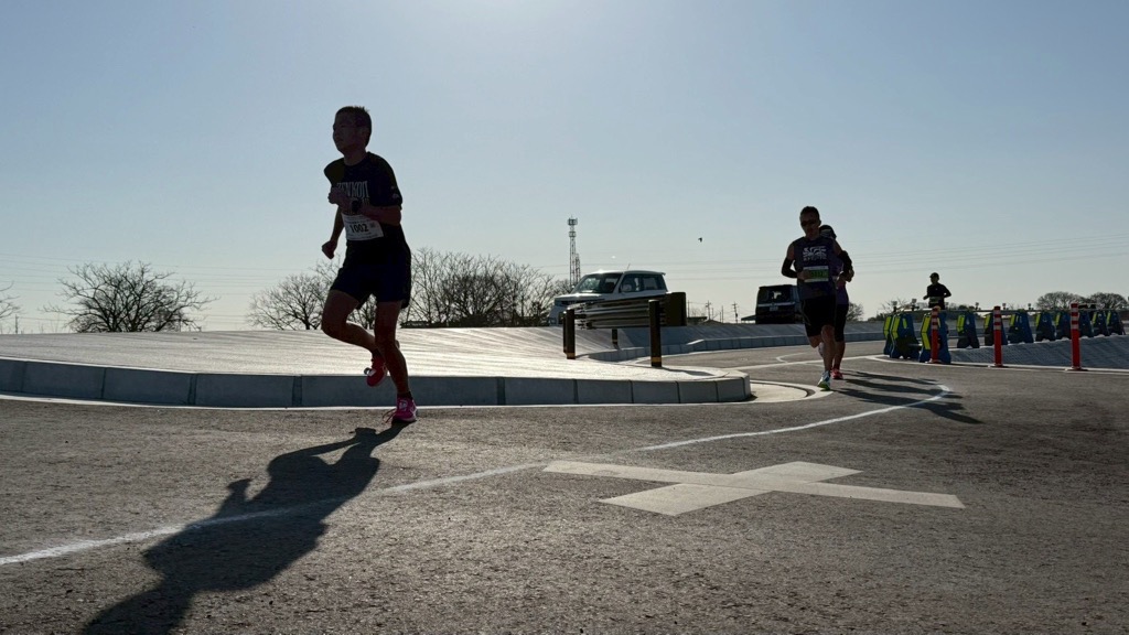 二人のランナーが道路を走っているシルエットの画像