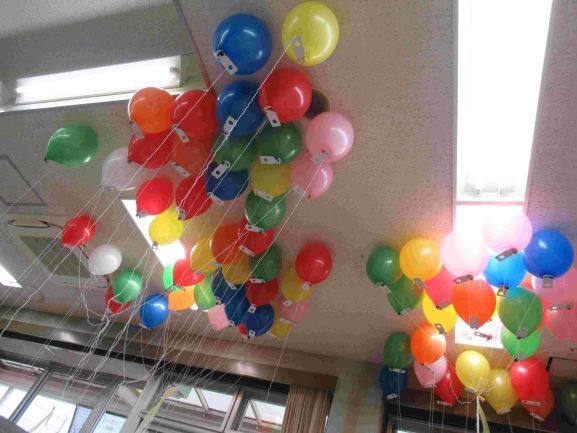 天井に集まるカラフルな風船の写真