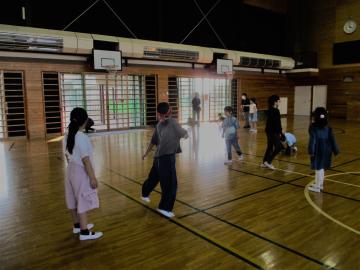 体育館でドッジビーをし指導員が見守っている場面