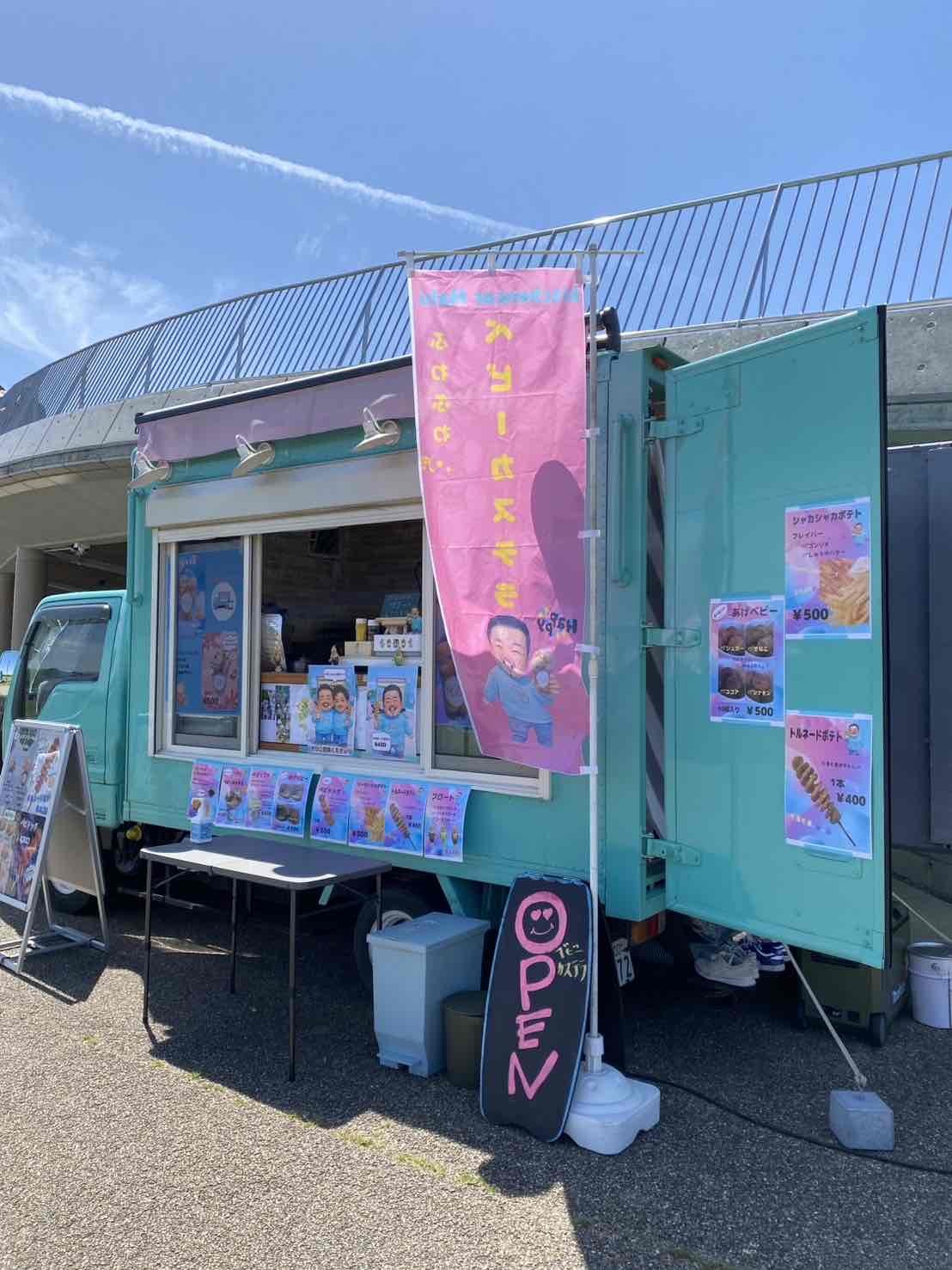 エメラルドグリーンを基調としたキッチンカーで、店名はキッチンカーマル。